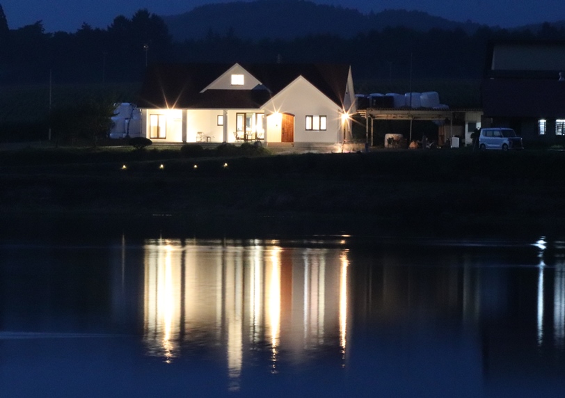 岩手の注文住宅：水鏡に映る夜の家の画像